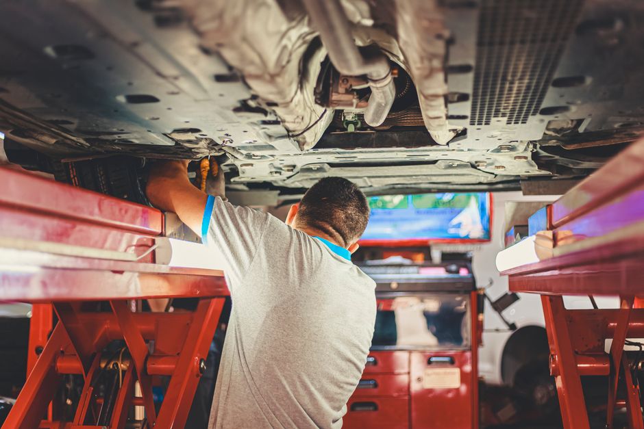 Personne inspectant le moteur d une voiture d occasion capot ouvert