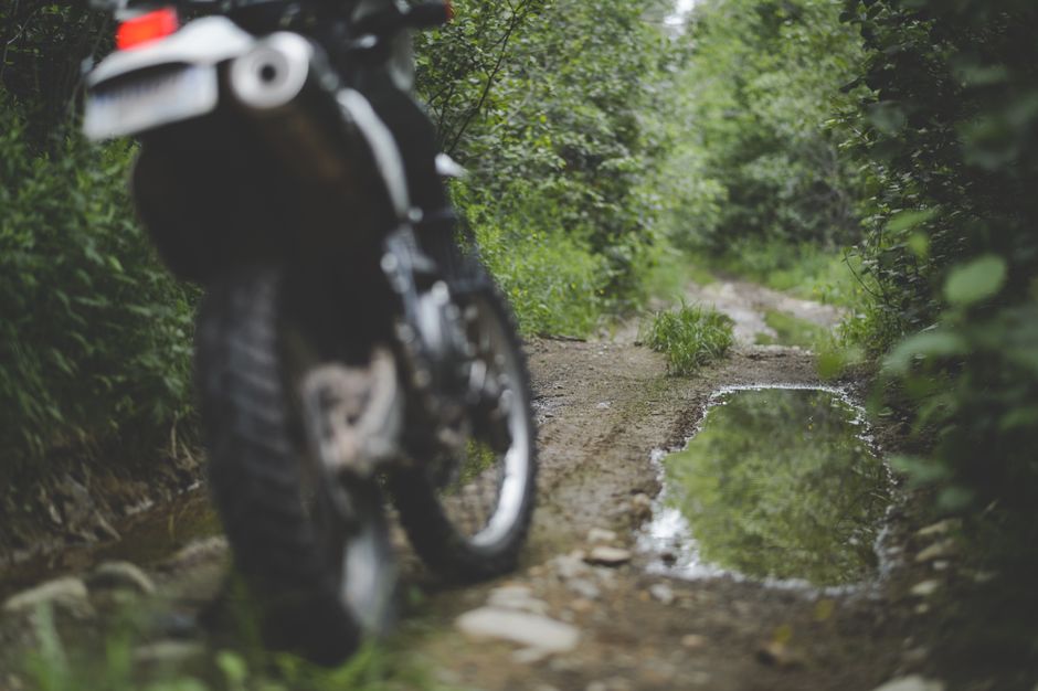 Moto de trail garee sur un chemin de campagne entoure de nature